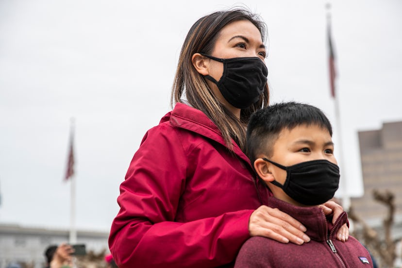Minji Wong of San Francisco stands behind her nine-year-old son Miles while attending a "Love our Pe...