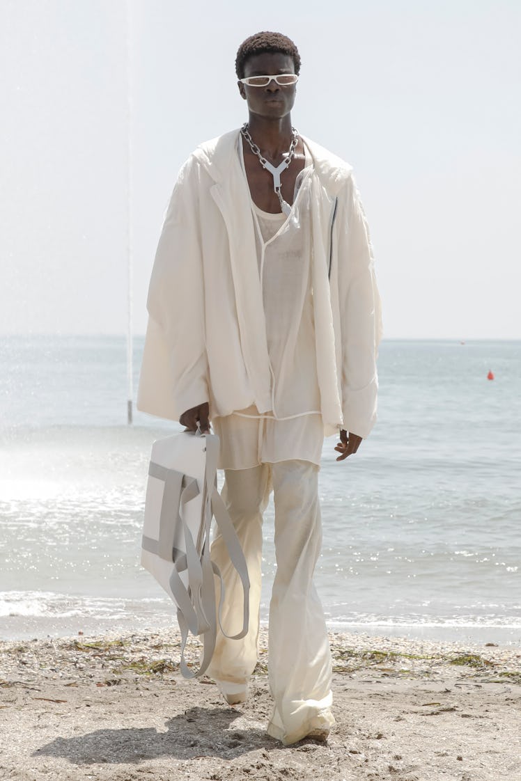 A model in a white shirt, jacket and trousers by Rick Owens at Men’s Fashion Week Spring 2022