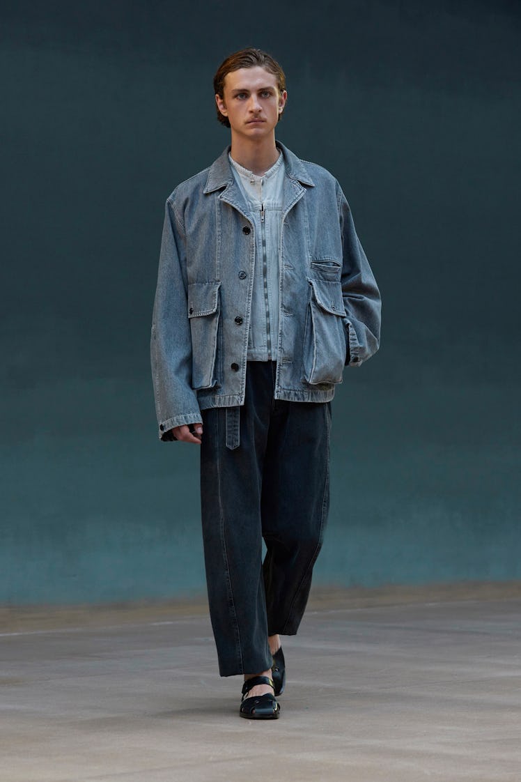 A model in a denim shirt, denim jacket and denim trousers by Lemaire at Men’s Fashion Week Spring 20...