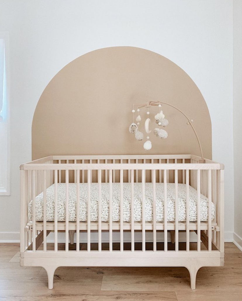 baby nursery with painted arch behind crib