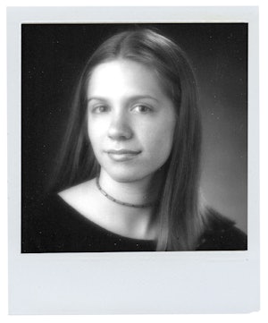 K.Flay at 17. with a long brown hair, wearing a black shirt and a choker necklace