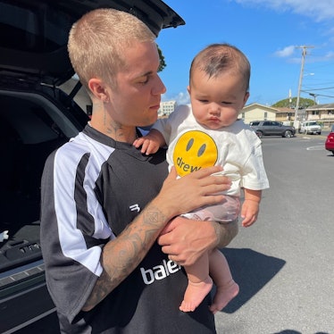 Justin Bieber sporting a buzzcut and holding a baby