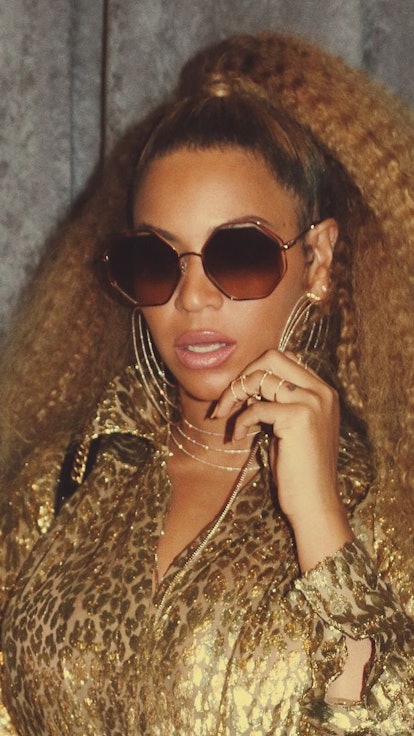 Beyoncé in gold with crimped hair posing 