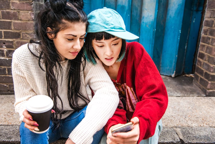 A pair of roommates on a stoop, texting using a funny group chat name.