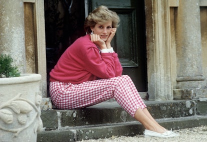 Diana, Princess of Wales (1961 - 1997) sitting on a step at her home, Highgrove House, in Doughton, ...