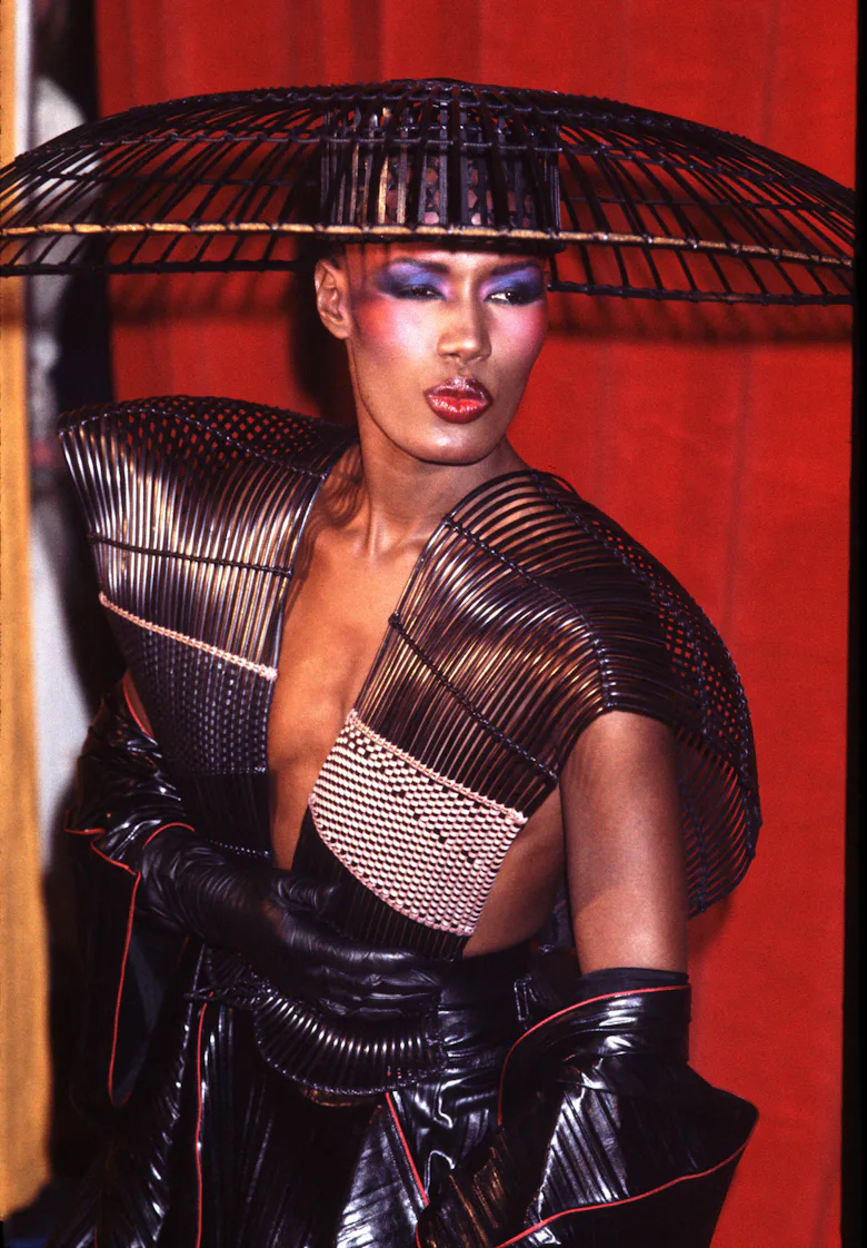 grace jones purple dress In the early 1980s, Grace Jones became closely associated with the work of Azzedine Alaa. His clothes, known for their precision and structure, aligned naturally with her physical presence and performance style
