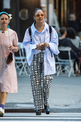 Tessa Thompson wearing a half-tucked stripe shirt and patterned pants while walking around in New Yo...
