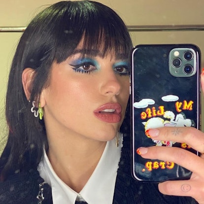 Dua Lipa posing with phone and floral French manicure