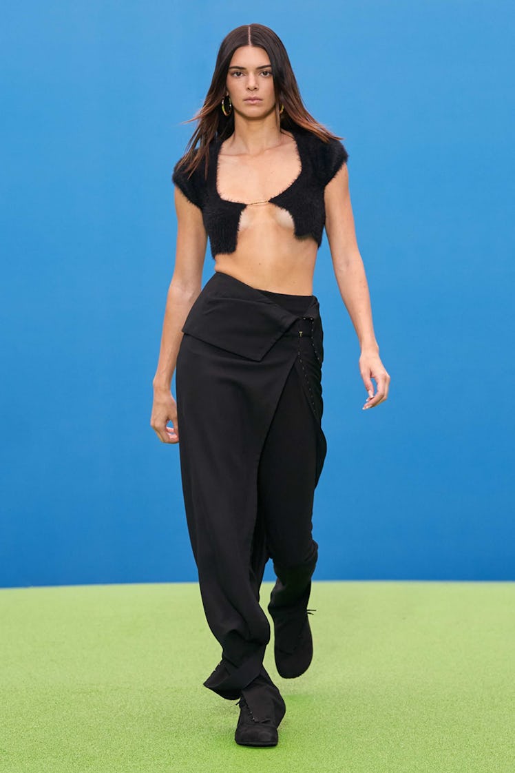 A model walking the runway in a black Jacquemus cropped cardigan and pants 