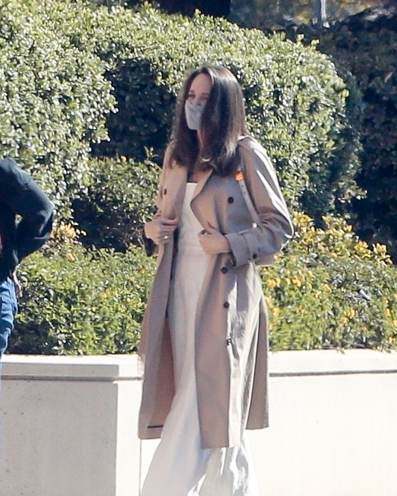 Angelina Jolie wearing a beige trench coat.