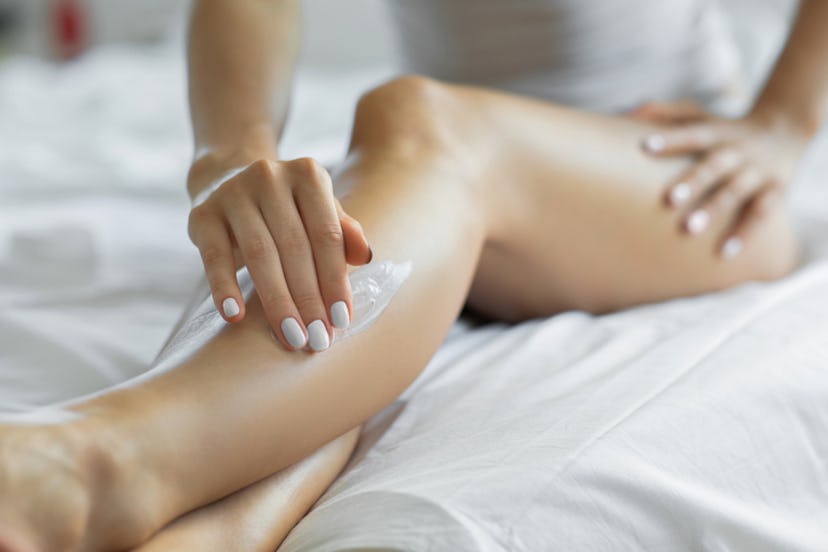 Woman applying cream to her legs