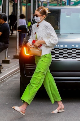 Gigi Hadid wearing green pants and Franco Sarto Bordo sandals in cream.