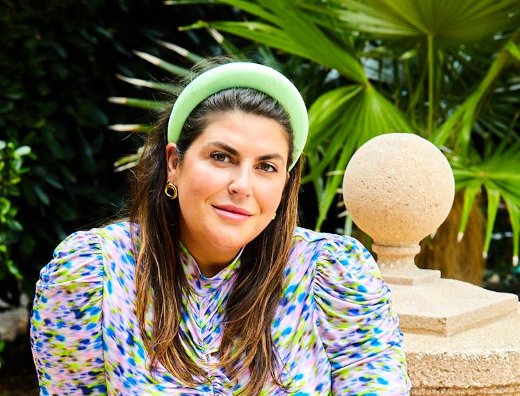 Katie Sturno in a purple, blue and green dress and a green headband