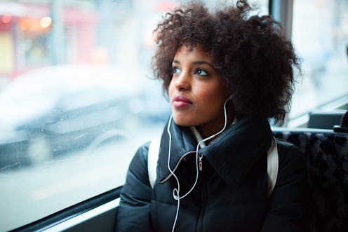 Woman with headphones on public transport.