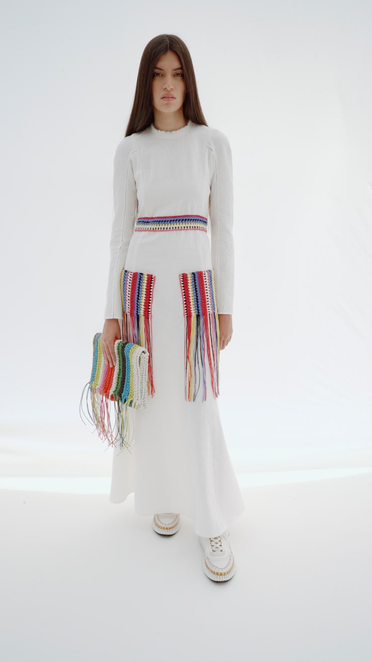 A model posing in a white Chloé knit dress