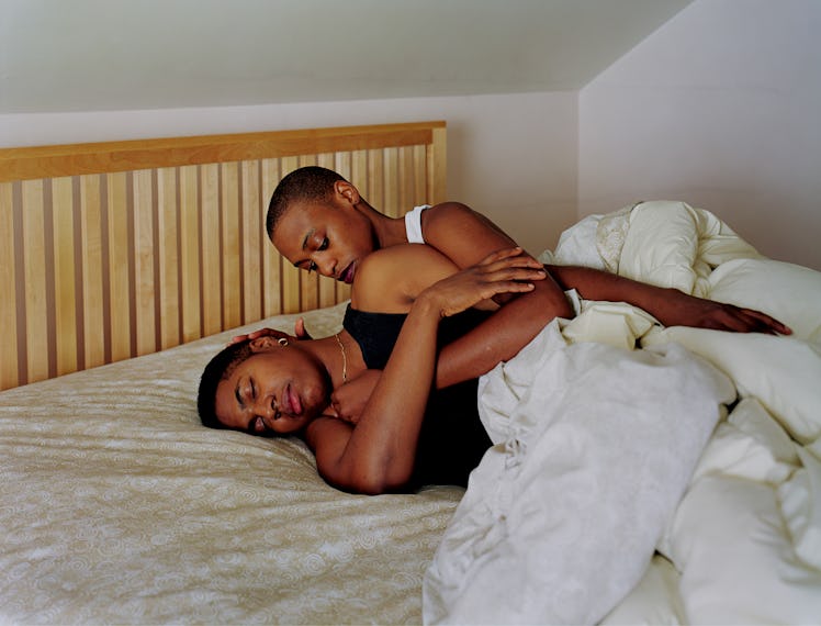 Two women named Gina & April photographed by Catherine Opie hugging in their bed