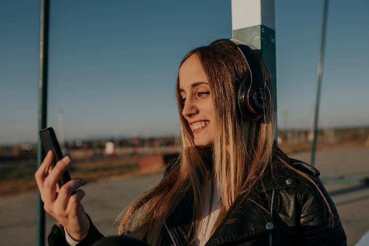 Young woman smiling at a text from her best friend.