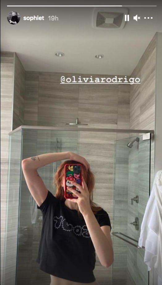 Sophie Turner showing off new, red hair in her bathroom mirror while wearing an Olivia Rodrigo t-shi...
