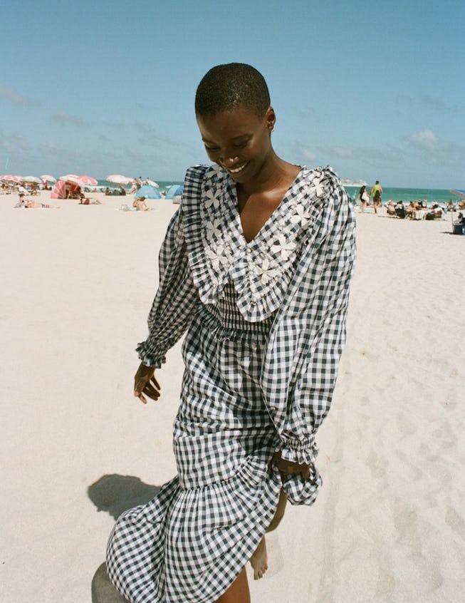 On the beach, a girl wears a black and white Cottagecore dress