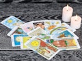 Set of tarot cards (as opposed to oracle decks) with candles.