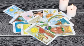 Set of tarot cards (as opposed to oracle decks) with candles.