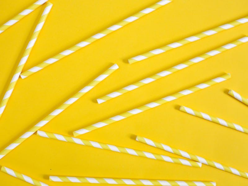 Single use plastic straws on yellow background