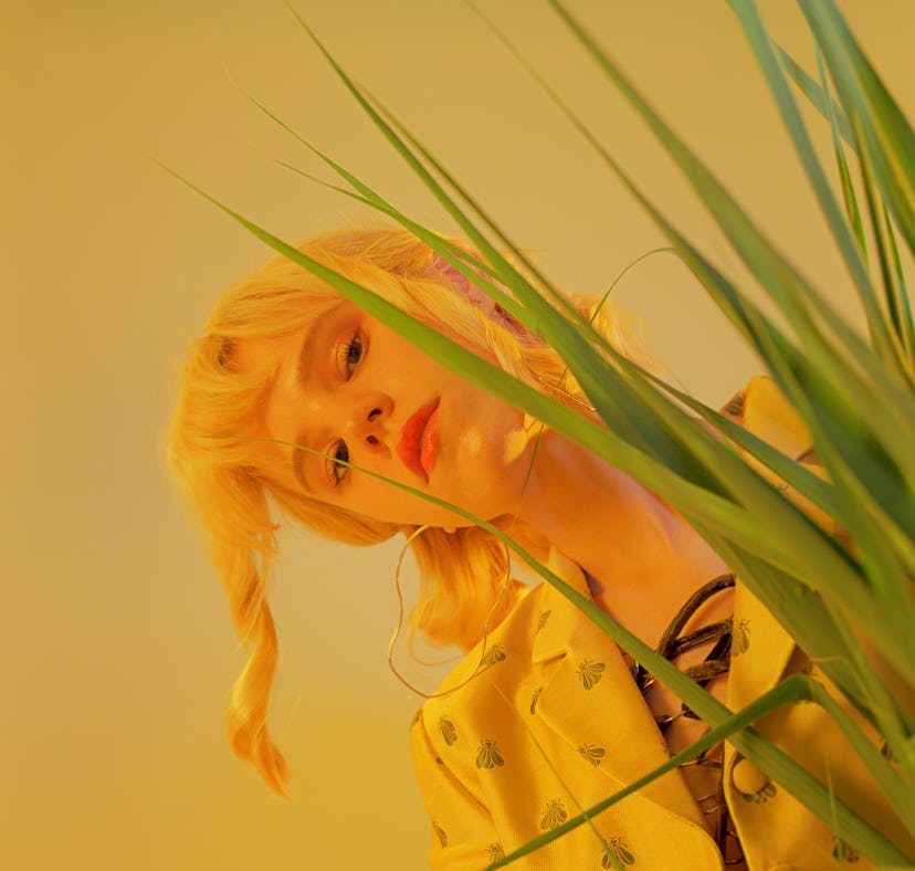 Young Pisces woman peeking out from behind a plant because she's difficult to understand.