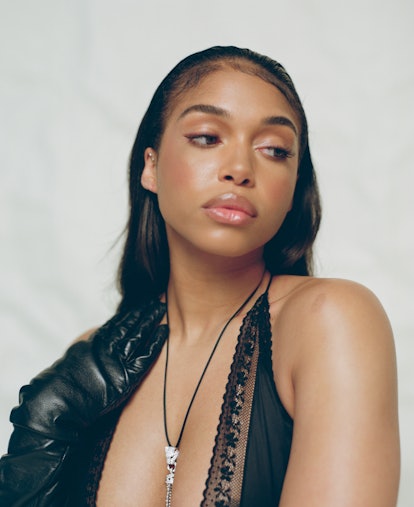 A close-up shot of model Lori Harvey wearing a black dress and black elbow-length gloves.