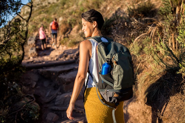 Young woman hiking, exercising her hips, thighs — her zodiac sign body parts.