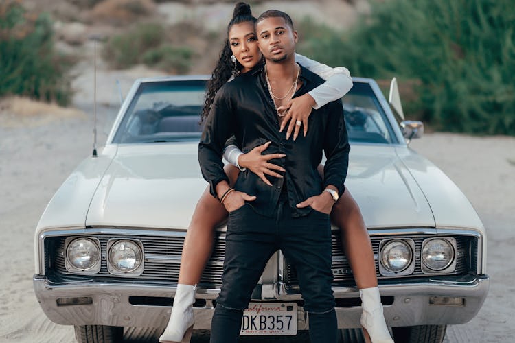 Khadeen and Devale sitting on the hood of a car