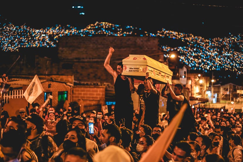 Columbian demonstrators carrying a white coffin on a street