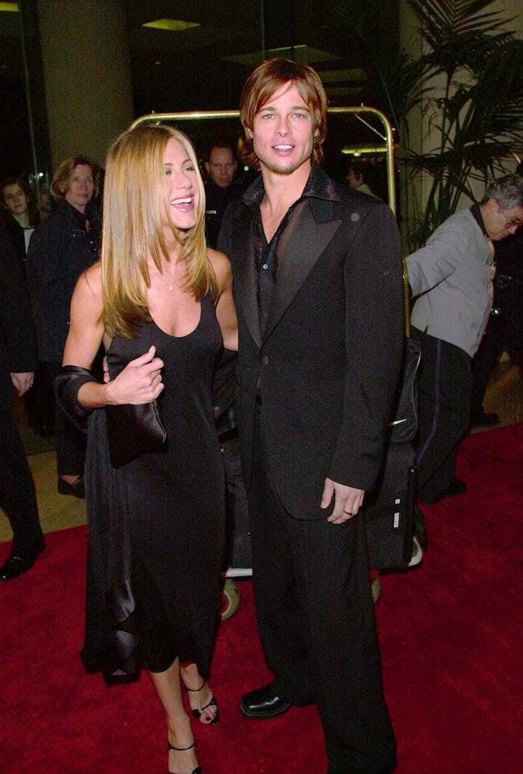 Jennifer Aniston and Brad Pitt dressed in black and smiling on the red carpet