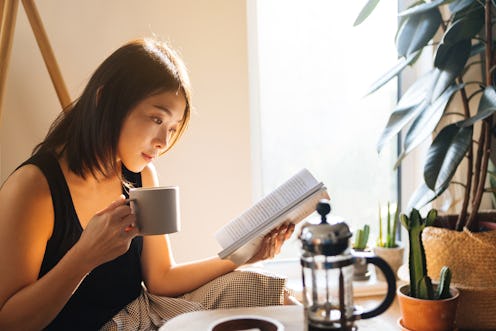 A woman reading with coffee.