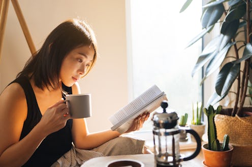 A woman reading with coffee.