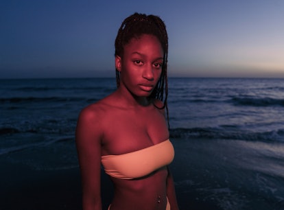 Young woman in a tube top bathing suit at the beach at night, showing the spiritual meaning of the J...
