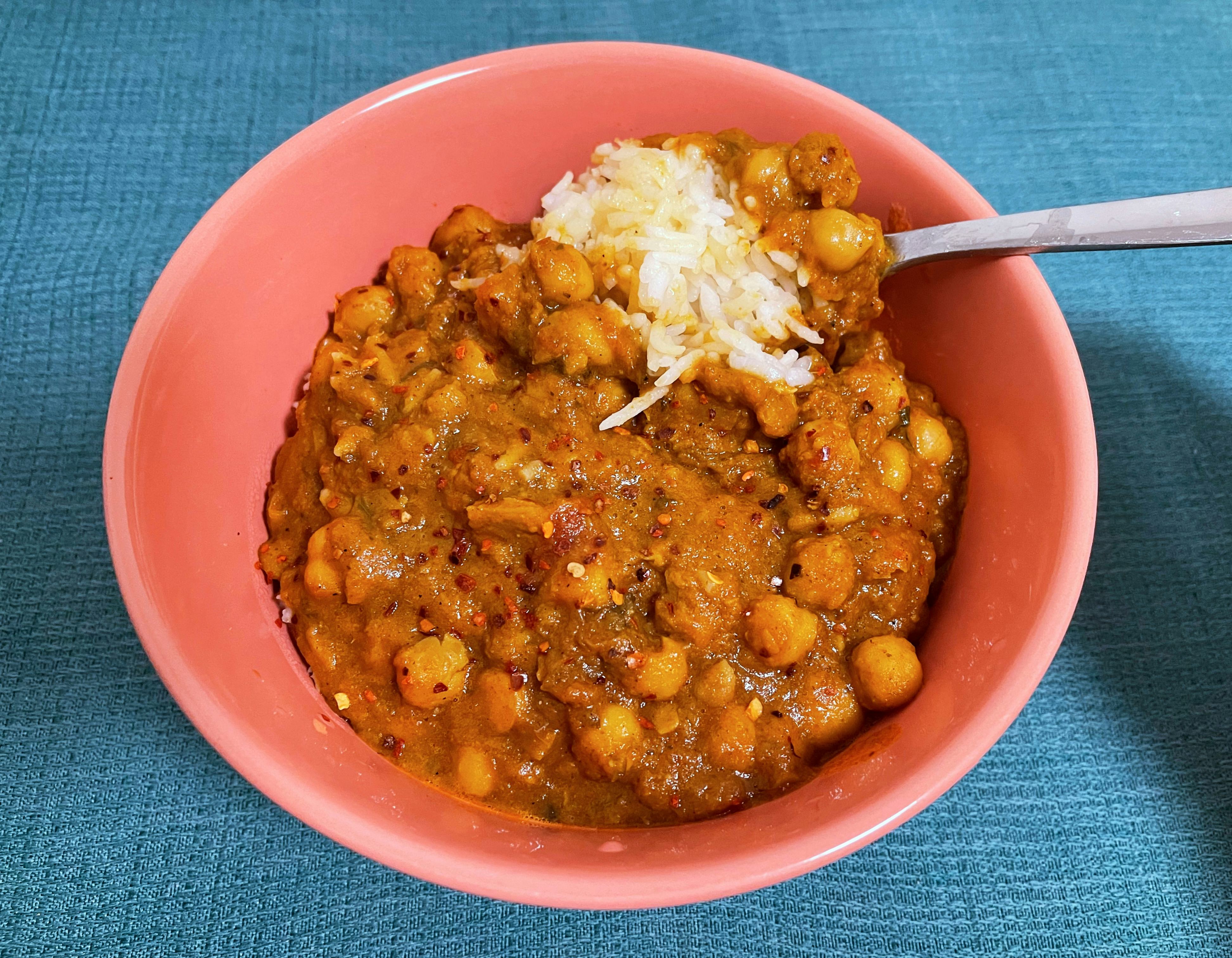 A bowl of chana masala on top of white rice.