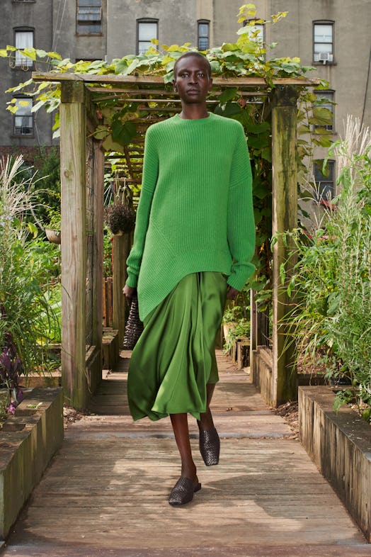 Model wearing a green jumper over a silk green dress