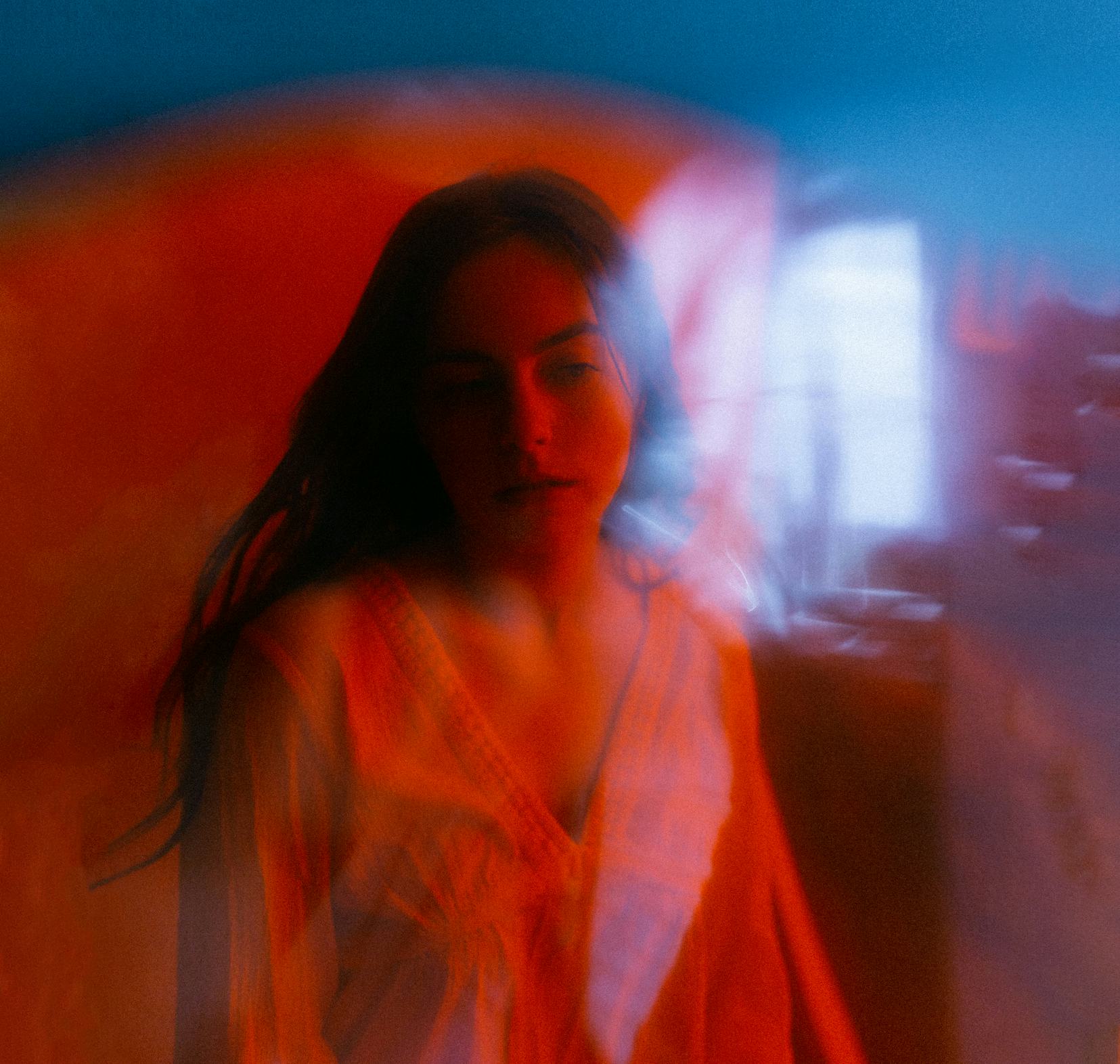 Young woman in red lighting wondering how the July 2021 new moon will affect her zodiac sign, per he...