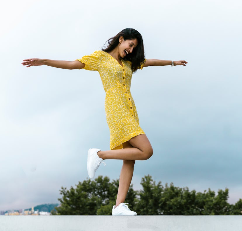 Young woman twirling in a floral summer dress, ready to post on Instagram with a sweet caption.