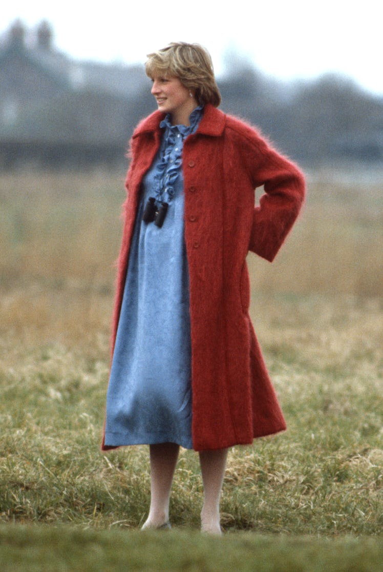 Princess Diana wearing a red coat in a field