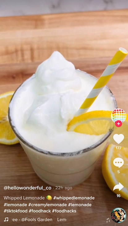 A whipped lemonade from TikTok sits on a counter with a fresh lemon slice on top. 