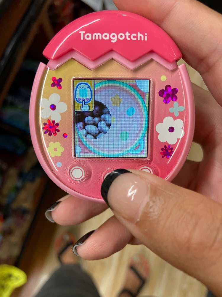 A pink Tamagotchi Pix is pictured displaying a photo of potatoes