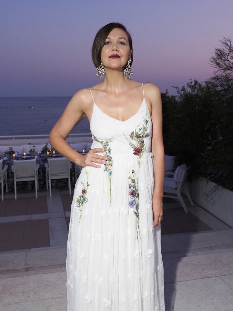 Maggie Gyllenhaal posing in a white dress