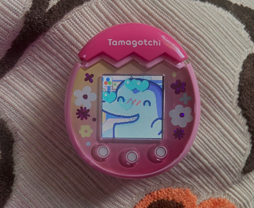 A pink Tamagotchi Pix is pictured with the character Ginjirotchi up close looking happy