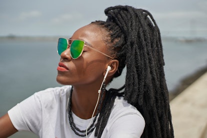 Young woman with green sunglasses looking into the distance to show how her zodiac sign deals with a...