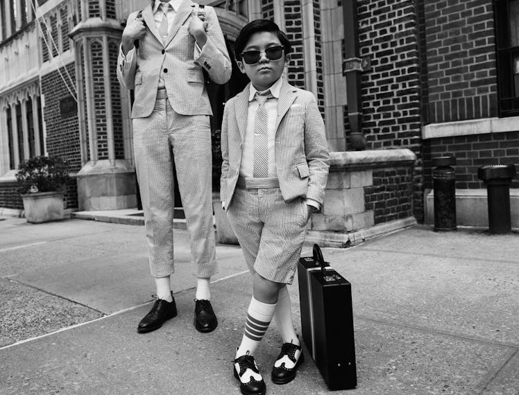 Alan Kim in Thom Browne's latest campaign dressed as an adult standing next to an adult male model