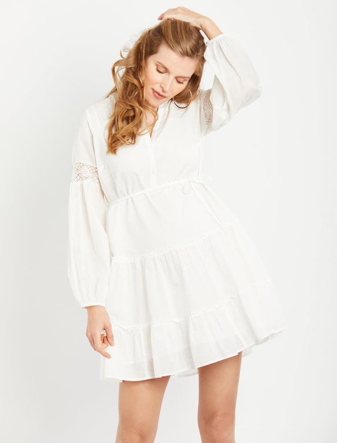 a white bohemian style maternity dress with long sleeves and crotchet details in the sleeve