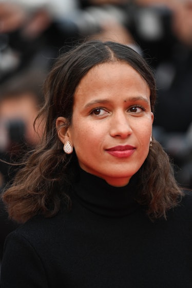 Mati Diop in a black dress and small beige earrings at the Cannes Film Festival 2021