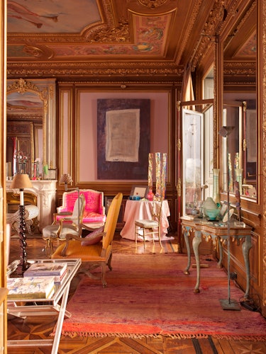 A living room in pink, orange and blush shades in the Provence Style with vintage furniture