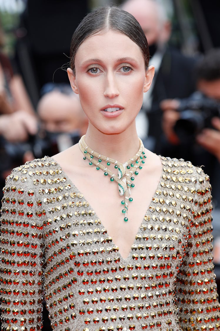 Ana Cleveland in a gold dress and beige-green necklace at the Cannes Film Festival 2021